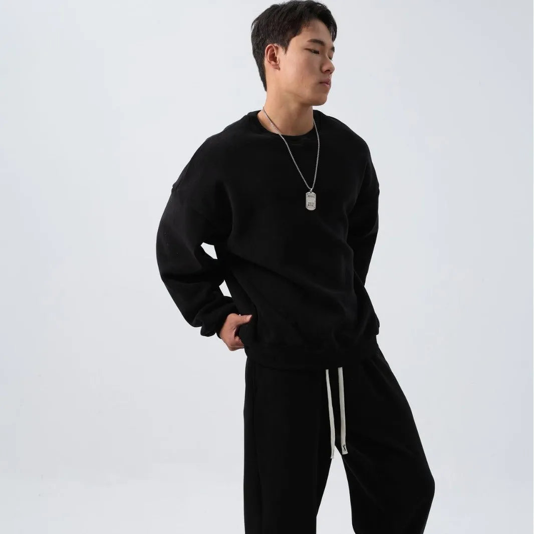 Man wearing a black loose-fit polar fleece sports suit with crew neck top and padded trousers for winter.