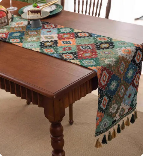 Long decorative table runner with tassels on a wooden dining table in a blue ginkgo leaf pattern.