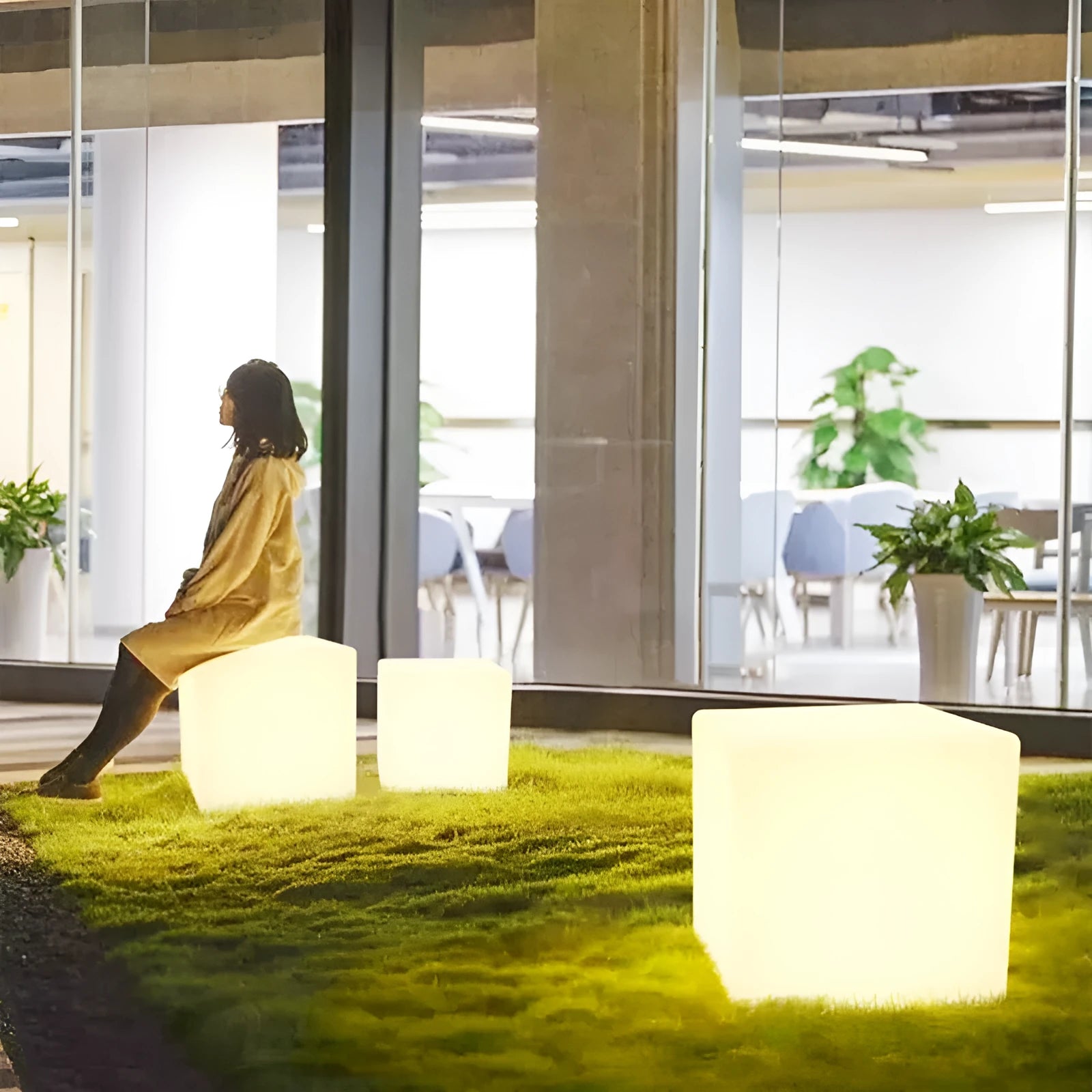 Modern square white LED cube light stool outdoors on a patio.