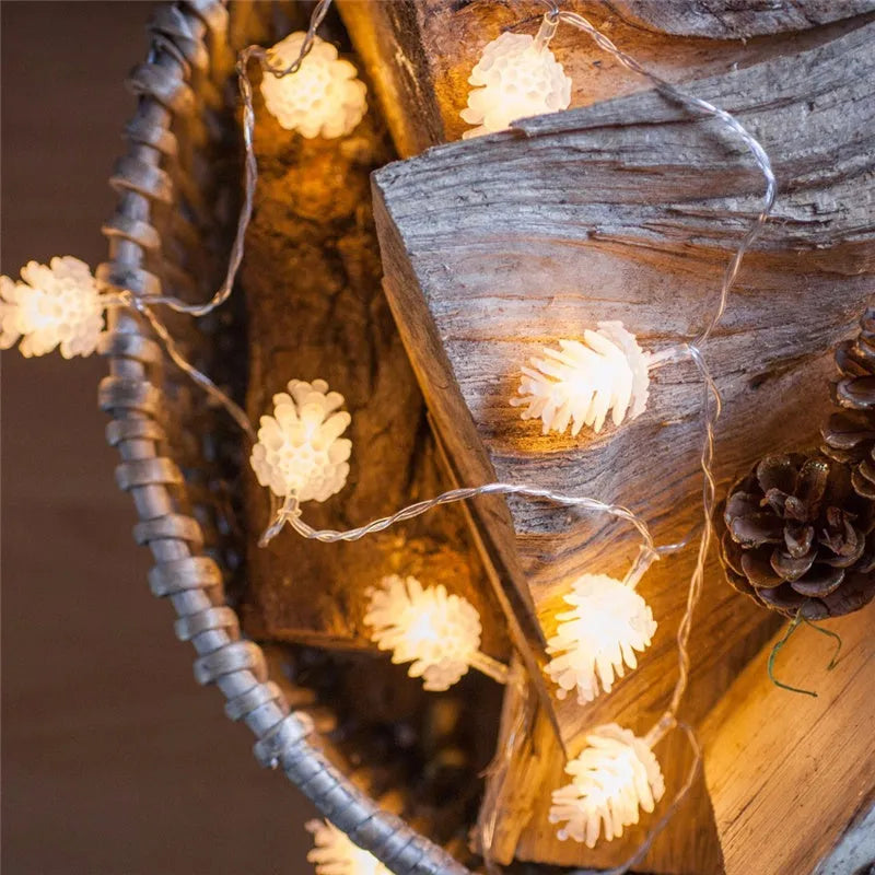 Warm white LED pine cone light string on a dark background, showing plastic shell details.