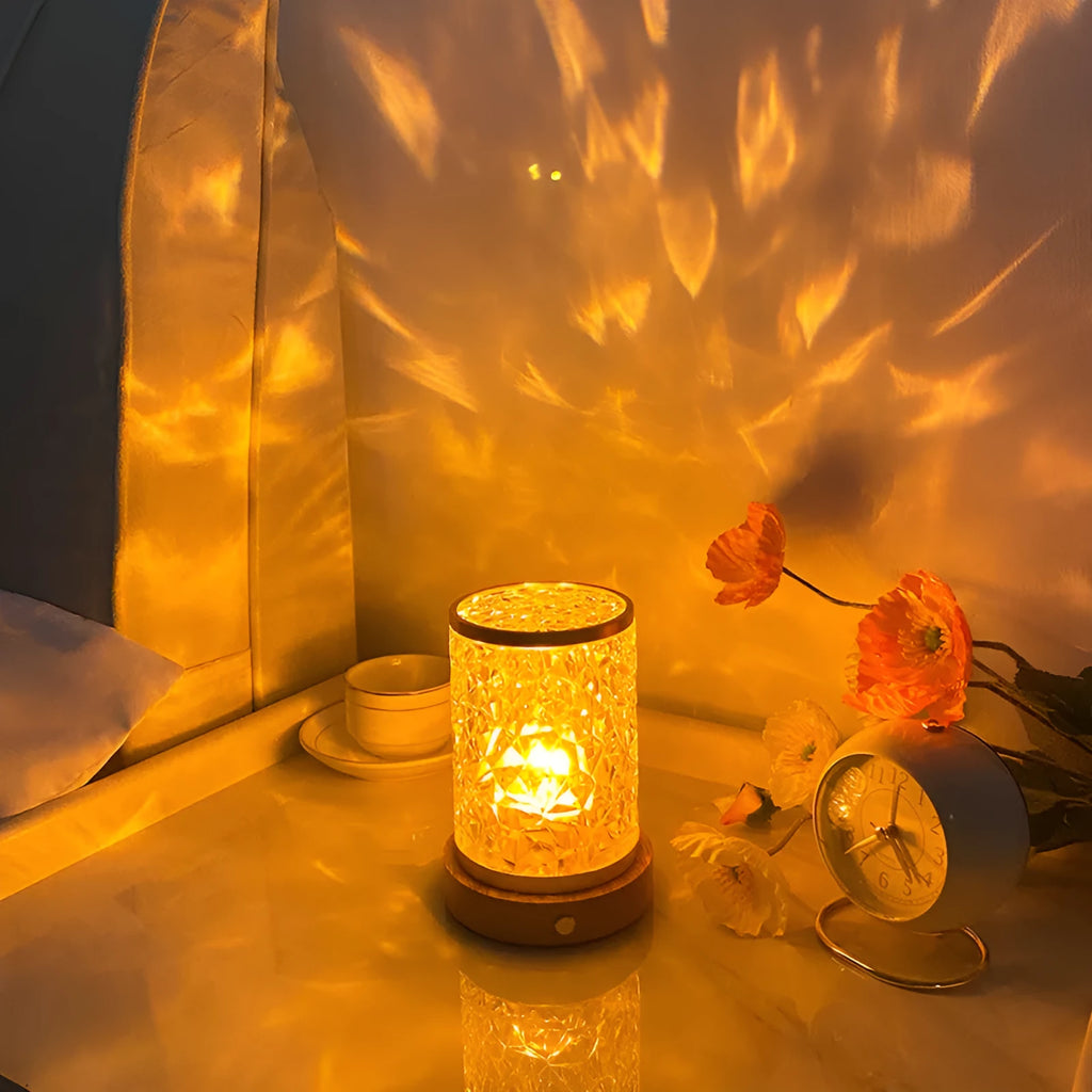 Small rotating water ripple night light with acrylic shade on a solid wood base.