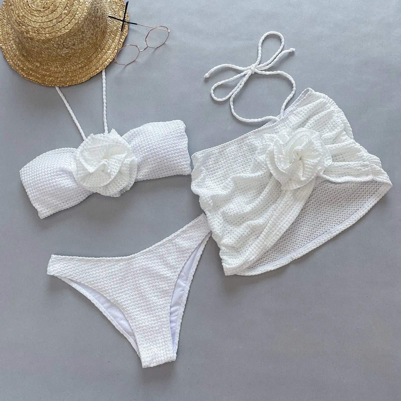 Women's white 3D flower split three-piece bikini set on a mannequin.