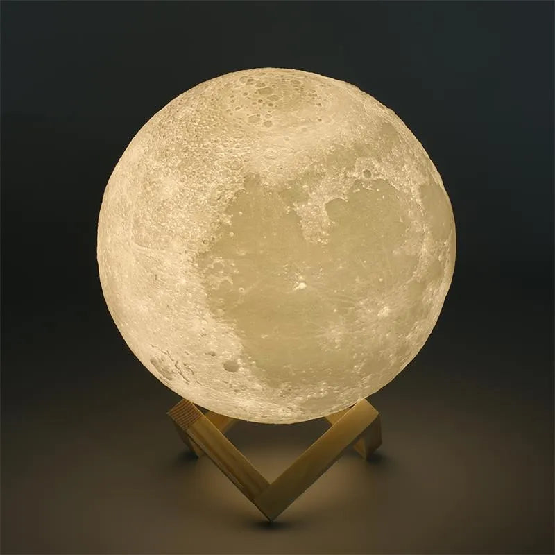 3D printed white moon lamp on a wooden stand with a glowing yellow light.
