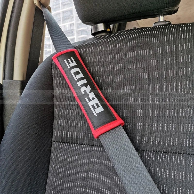 Black car seatbelt shoulder pad made of sponge cloth and cotton, showing embroidery weave detail.