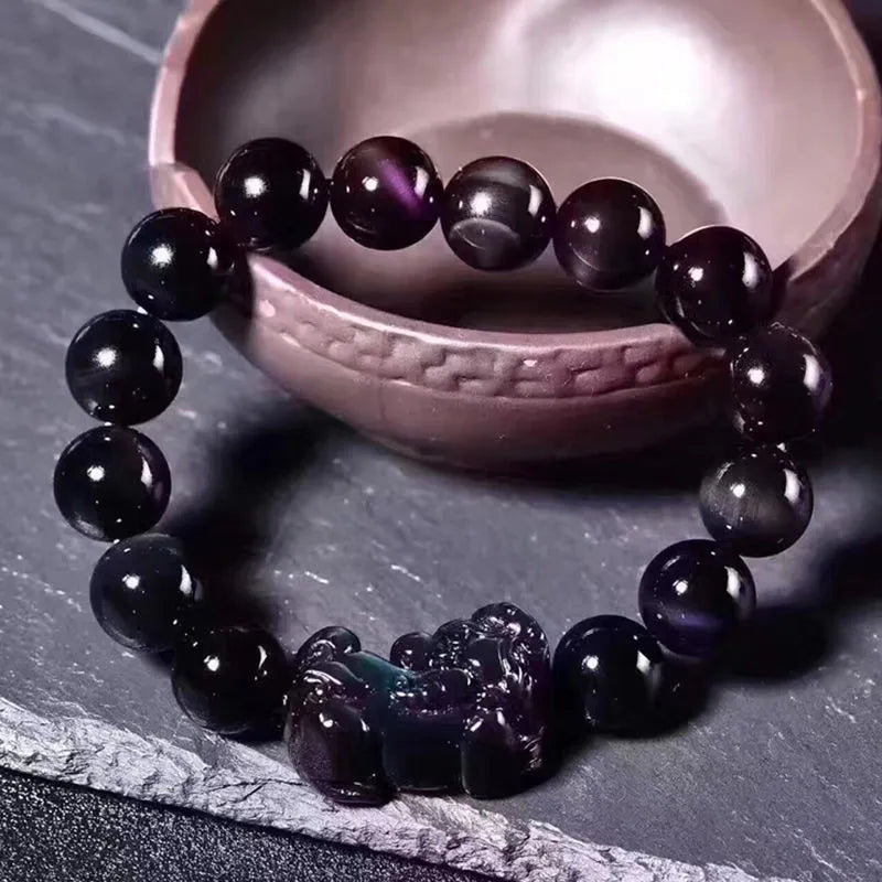 Natural ice colour eye obsidian crystal bead bracelet on a wrist, showing unisex design.