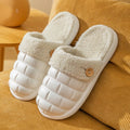 Pink and grey detachable EVA house slippers with plush lining and non-slip sole on a wooden floor.
