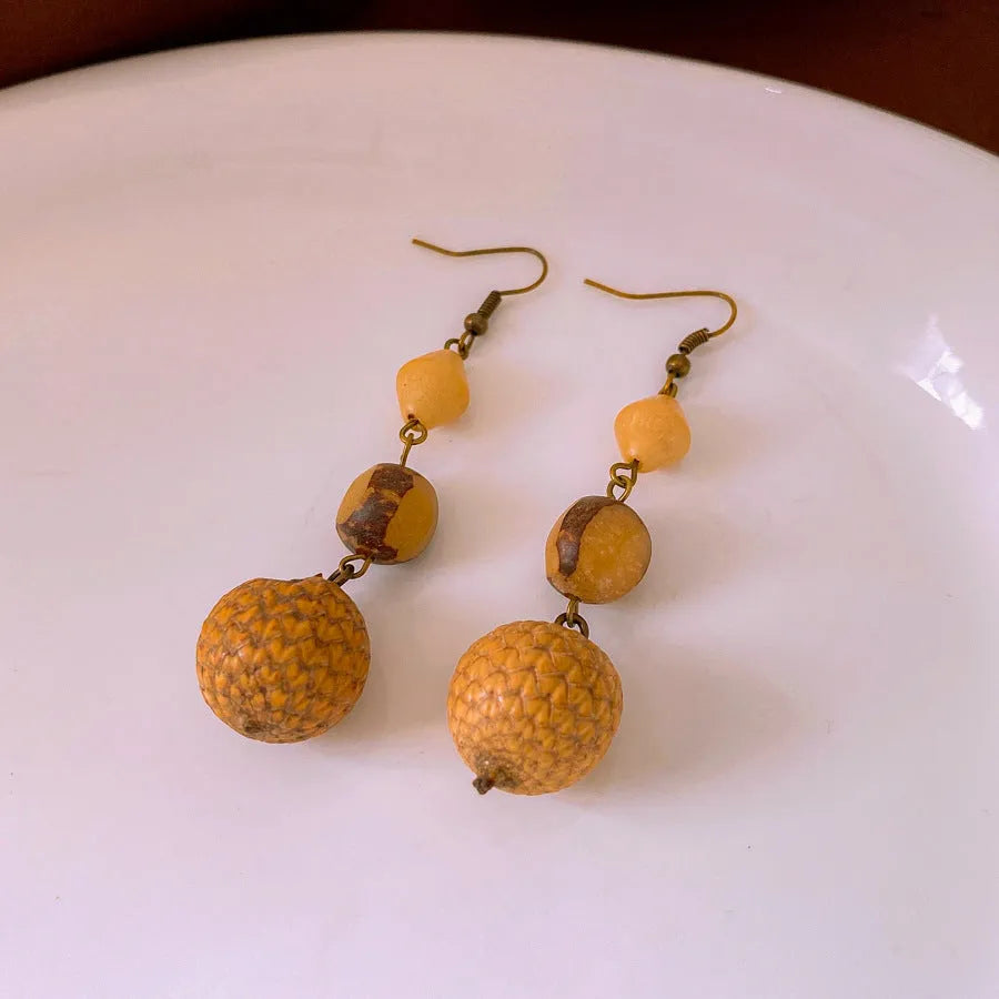 Retro ethnic style brown resin fruit core tassel earrings with geometric round design for women.