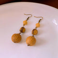 Retro ethnic style brown resin fruit core tassel earrings with geometric round design for women.