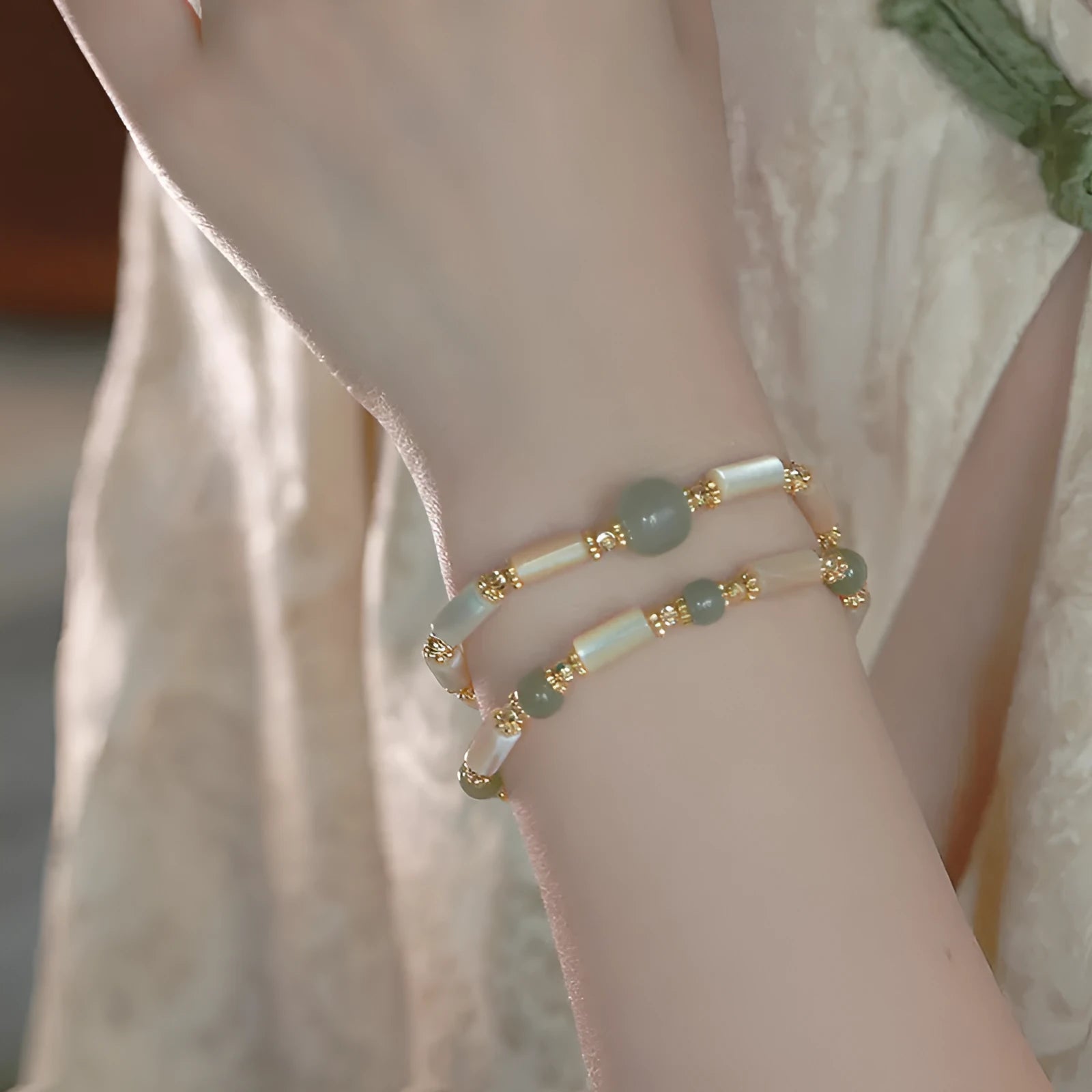 Natural Hetian jade and white lip shell round bead bracelet on neutral background, single bead option