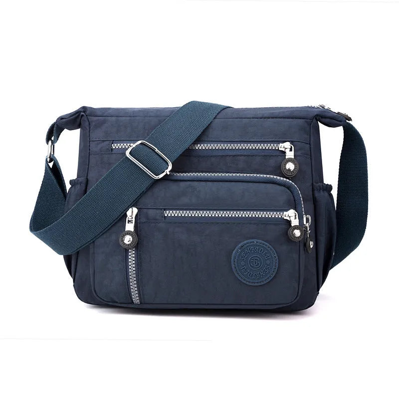 Grey nylon shoulder messenger bag with a single strap and square vertical shape on a neutral background.