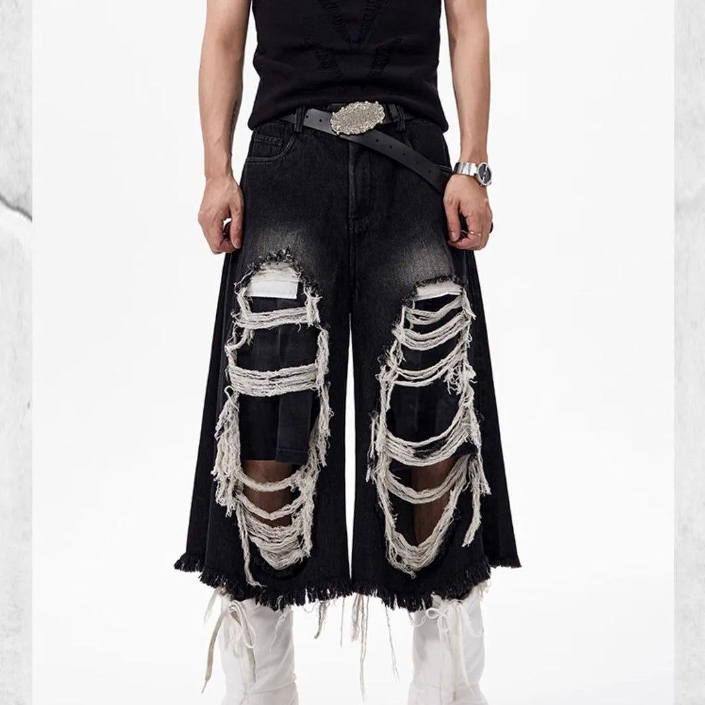 Black cropped wide-leg women's jeans with ripped patch detail on the knee.