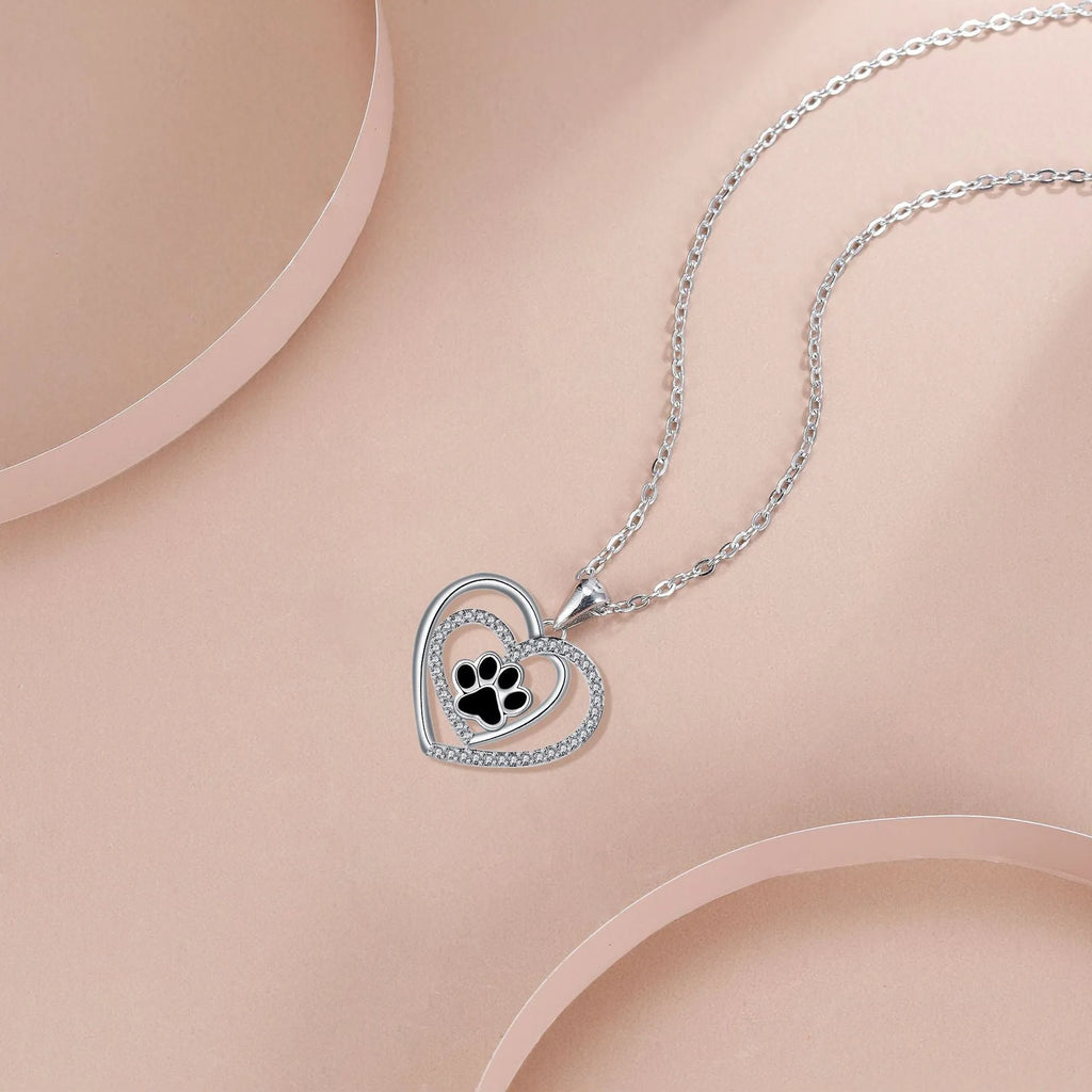 Copper heart pendant necklace with dog paw print detail on a cross chain.