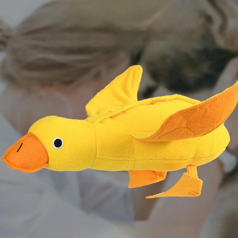 Yellow plush teddy duck dog training toy with squeaker and treat dispensing compartment.