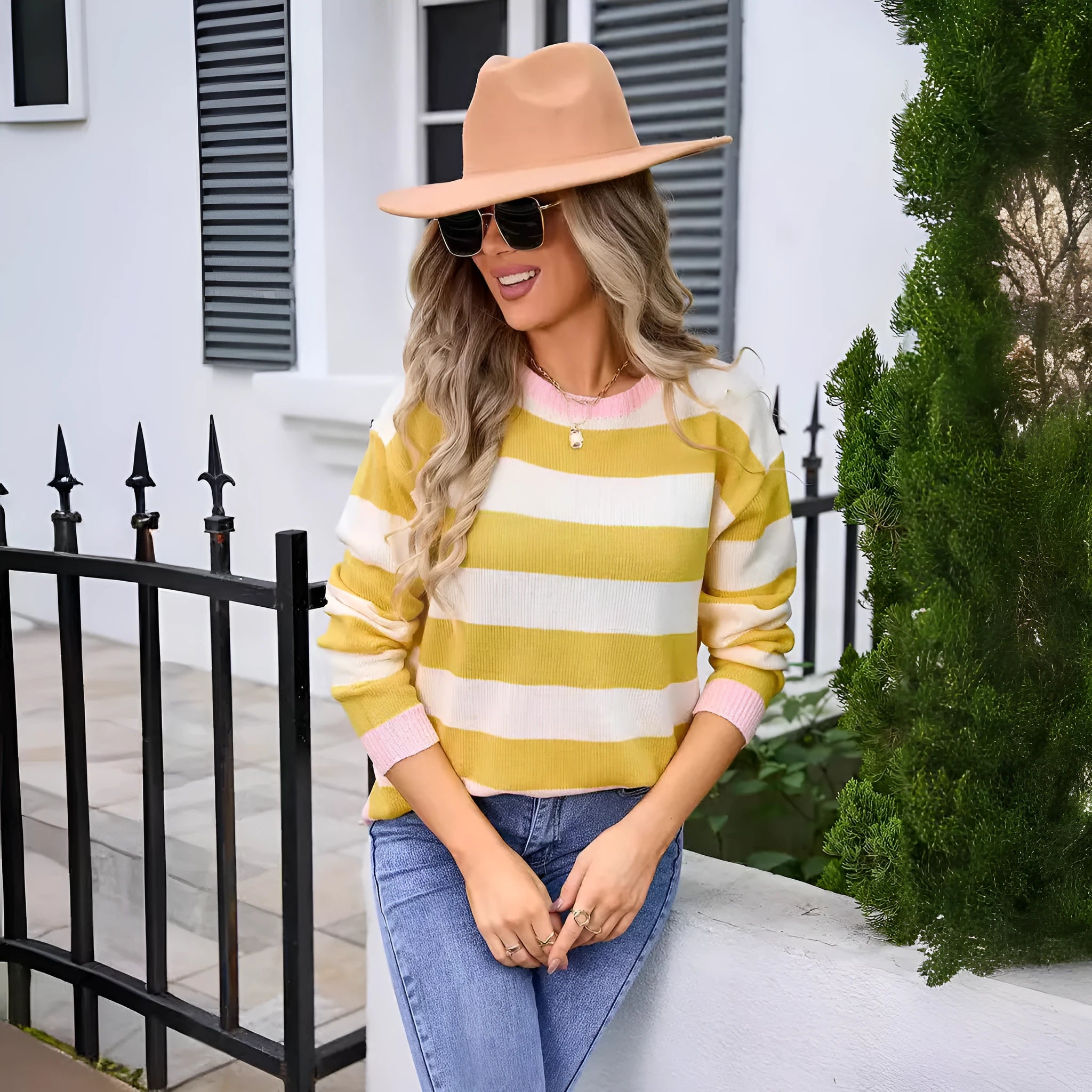 Women's loose fit long sleeve acrylic sweater in blue with a striped pattern, showing round neck.