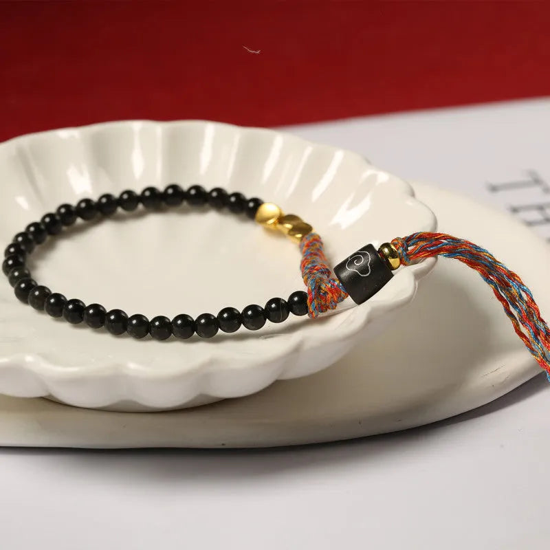Hand-woven obsidian carrying strap bracelet showing 4mm width and adjustable length