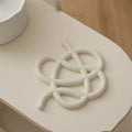 Ceramic heat proof mat with irregular shape in bright black colour on dining table