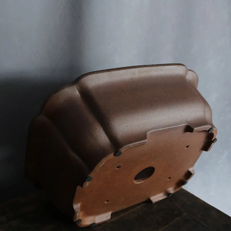 A modern rectangular flower pot made from purple sand ceramic, standing on a floor.