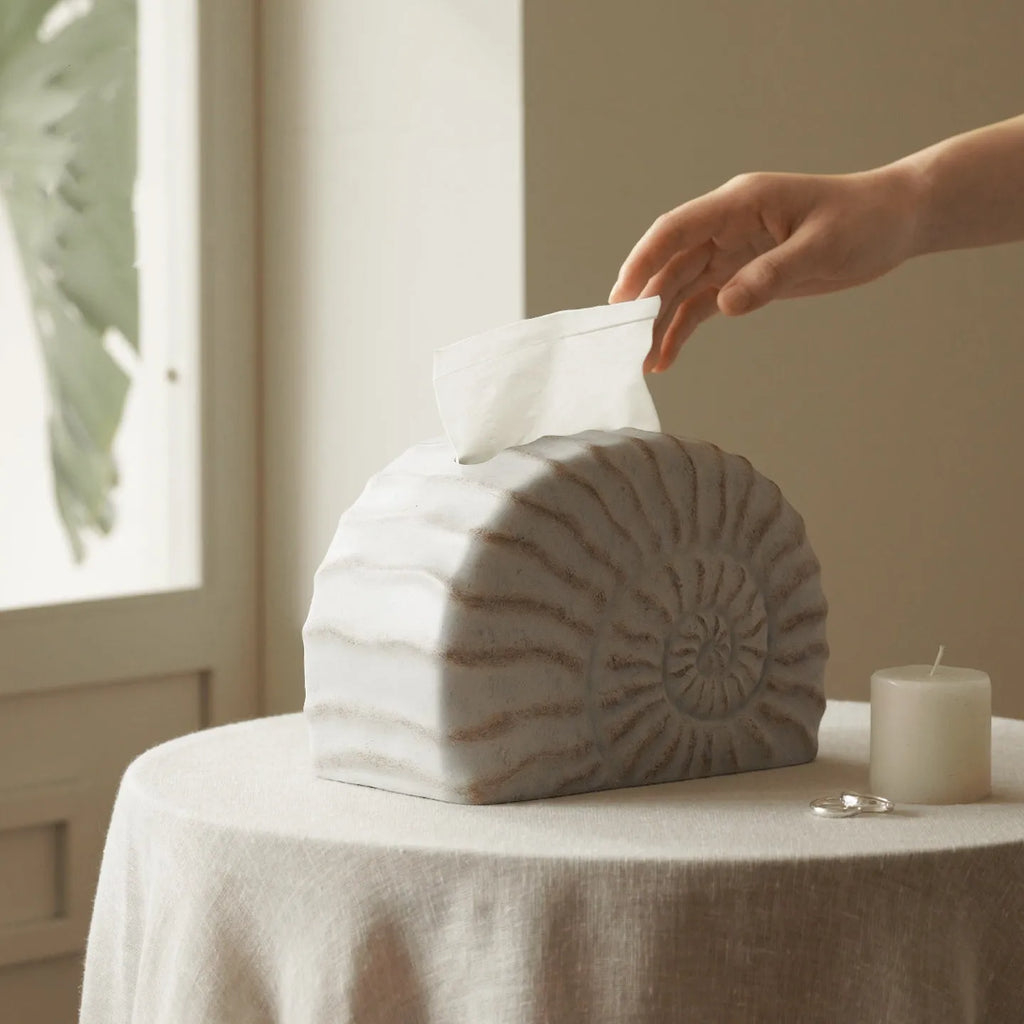 Modern conch ramble patterned resin decorative tissue box holder on a table.