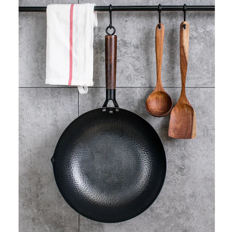 Traditional handmade iron wok pan with wooden handle and black finish