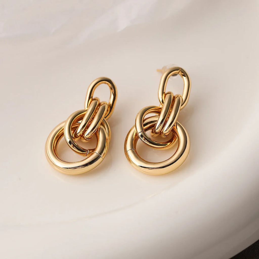 A pair of irregular geometric stud earrings in gold colour, made from copper.