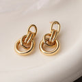 A pair of irregular geometric stud earrings in gold colour, made from copper.