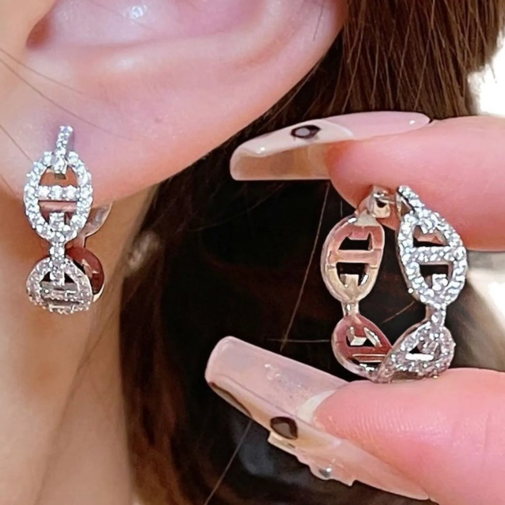 A pair of women's diamond-look fashion earrings with thick gold plating, shown in silver, gold, and rose gold colour options.