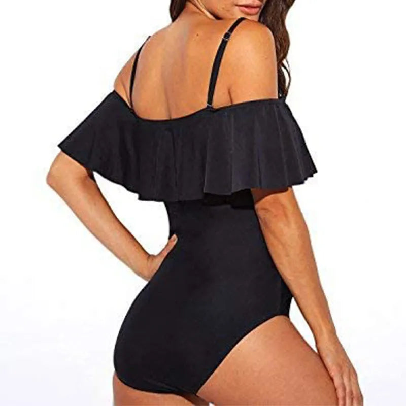 Black strapless one-piece swimsuit with side cut-out details and ruffled shoulder straps.
