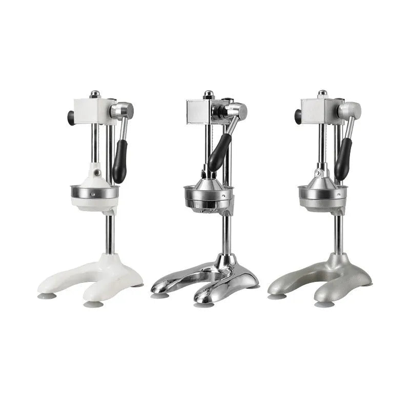 Vertical stainless steel manual juicer with choice of coloured finishes and head attachments on a kitchen worktop.