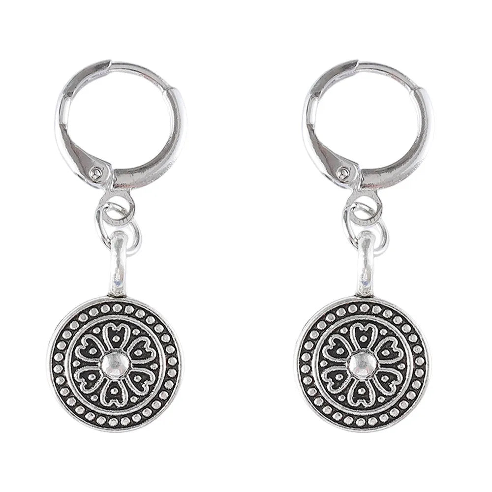 Close-up of a pair of women's geometric round bohemian retro style earrings with a distressed ethnic design in zinc alloy.