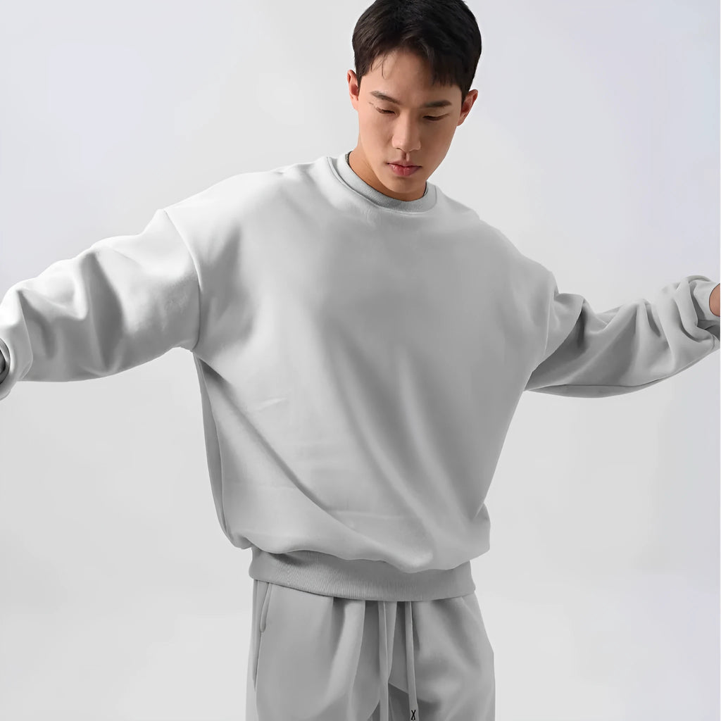 Man wearing a black loose-fit polar fleece sports suit with crew neck top and padded trousers for winter.