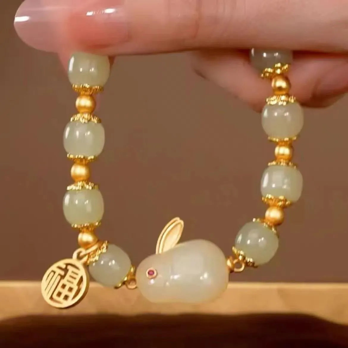 Women's green jade bracelet with fu character hare pendant and lily element on black adjustable cord