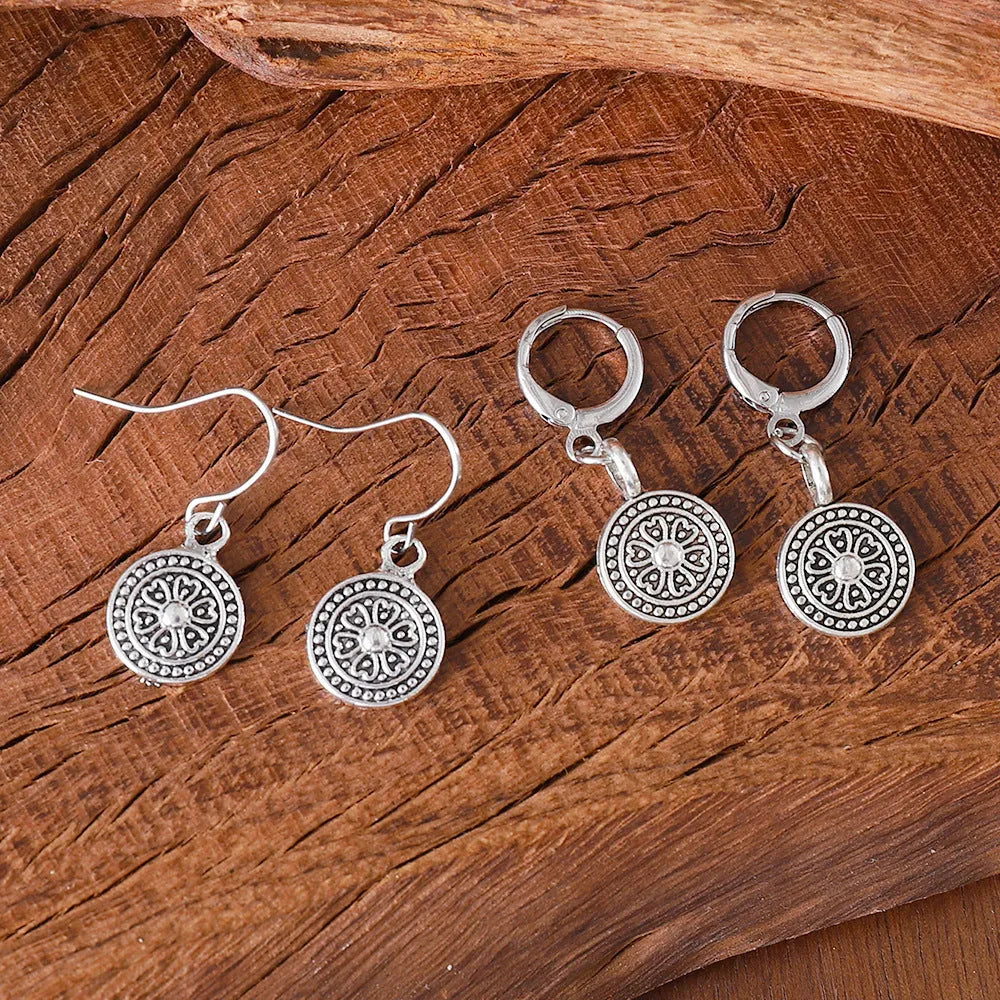 Close-up of a pair of women's geometric round bohemian retro style earrings with a distressed ethnic design in zinc alloy.
