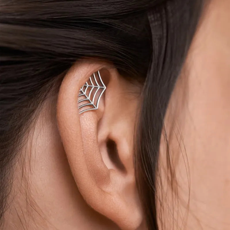 Spider web pattern stud earrings in gold and silver electroplated metal.