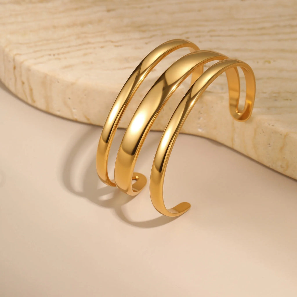 A simple open geometric stainless steel bracelet for women, shown in a gold tone finish.