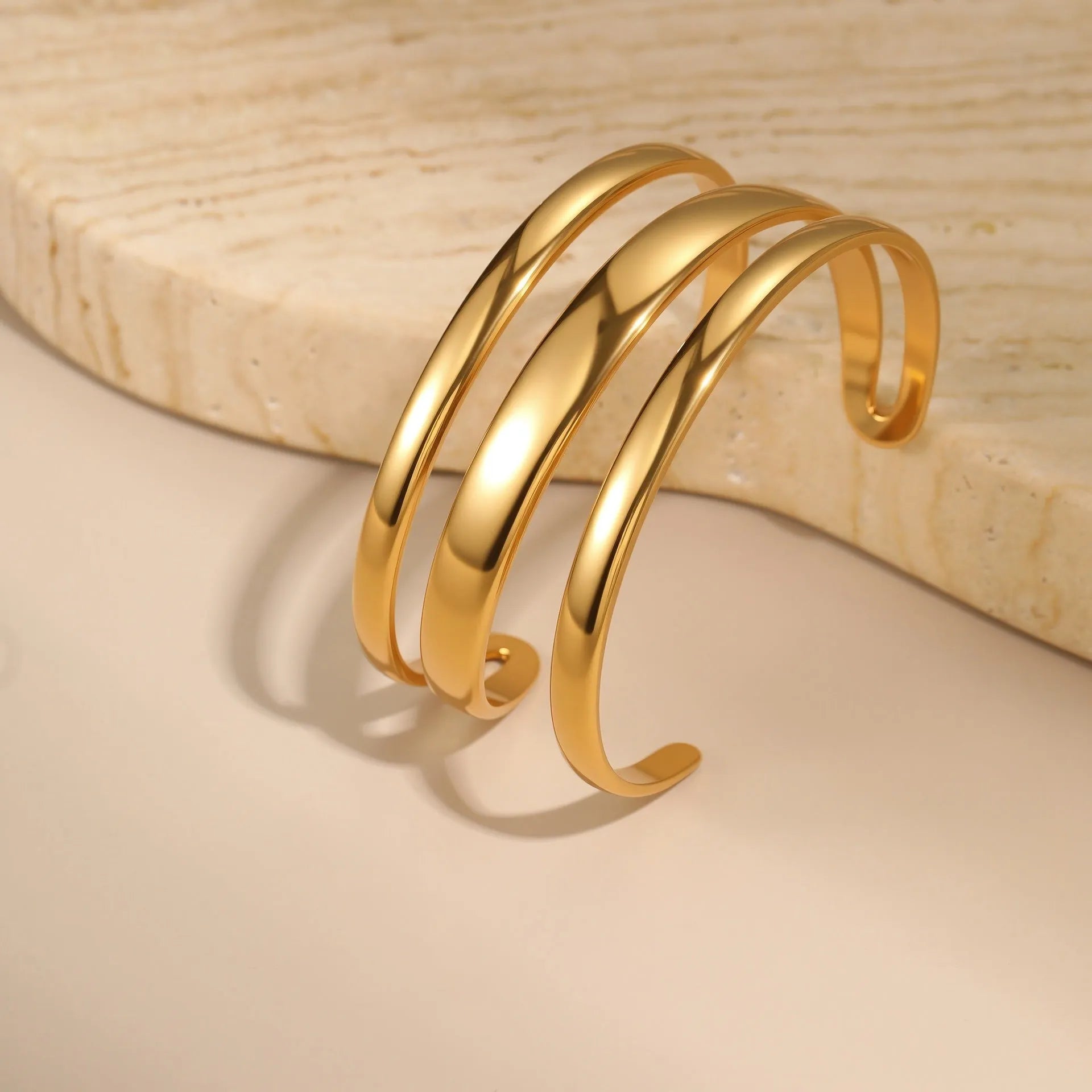 A simple open geometric stainless steel bracelet for women, shown in a gold tone finish.