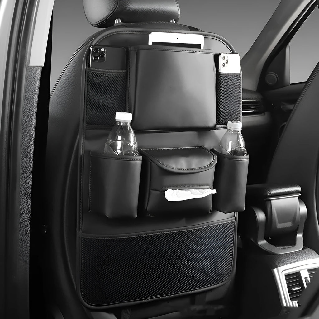 Black leather car seat back storage bag with pockets, shown suspended behind a car seat headrest.