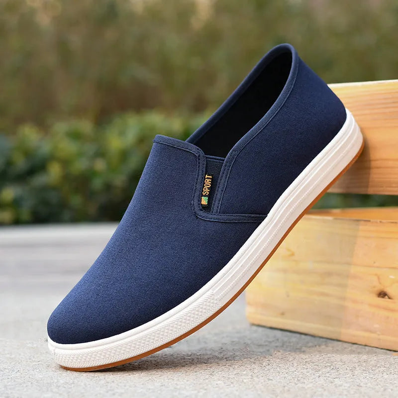 Men's low-top black and blue canvas slip-on shoes with round toe and shallow cut.
