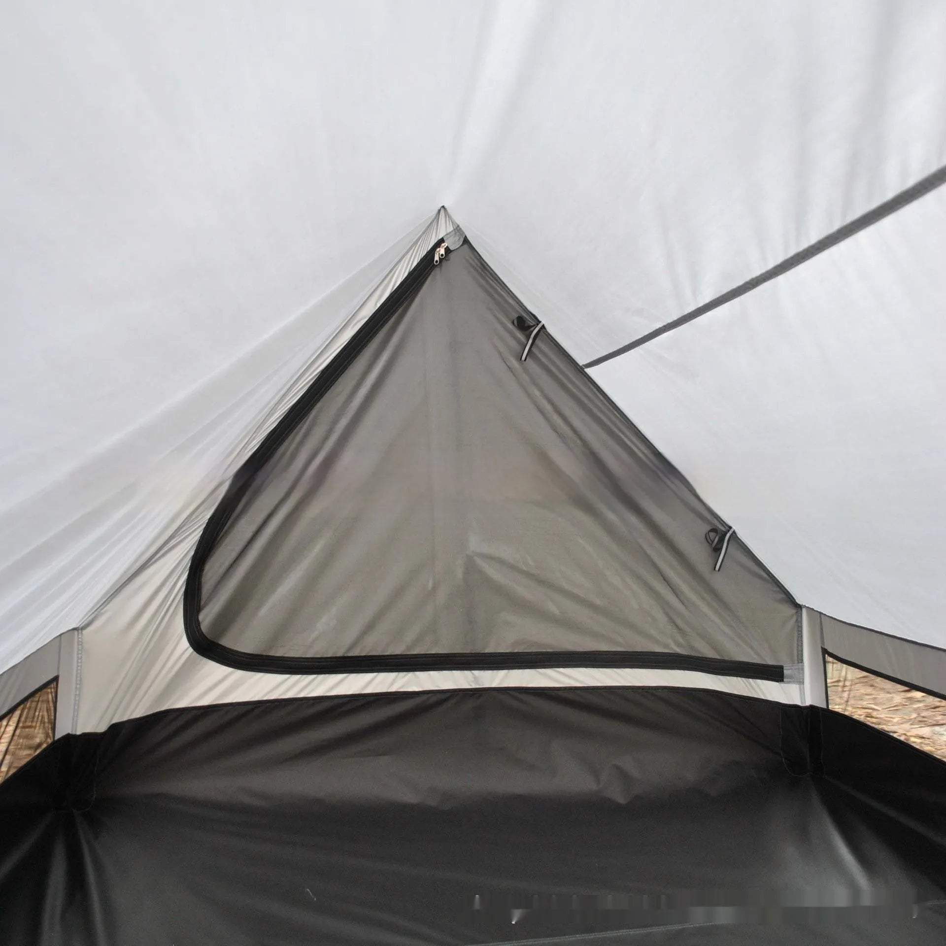 Brown A-frame hiking tent supported by hiking poles showing spacious interior for 2-3 campers
