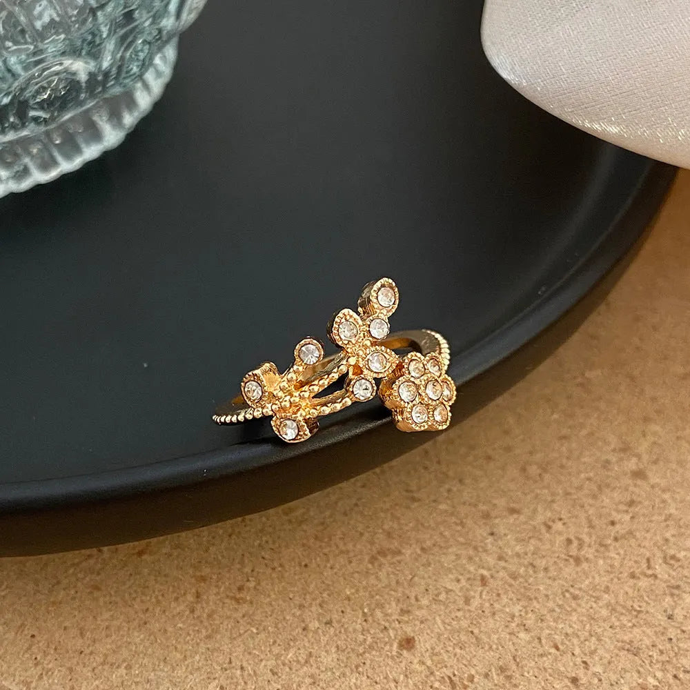 Women's open mouth copper ring with diamond-textured flower and leaves design in gold or white finish.