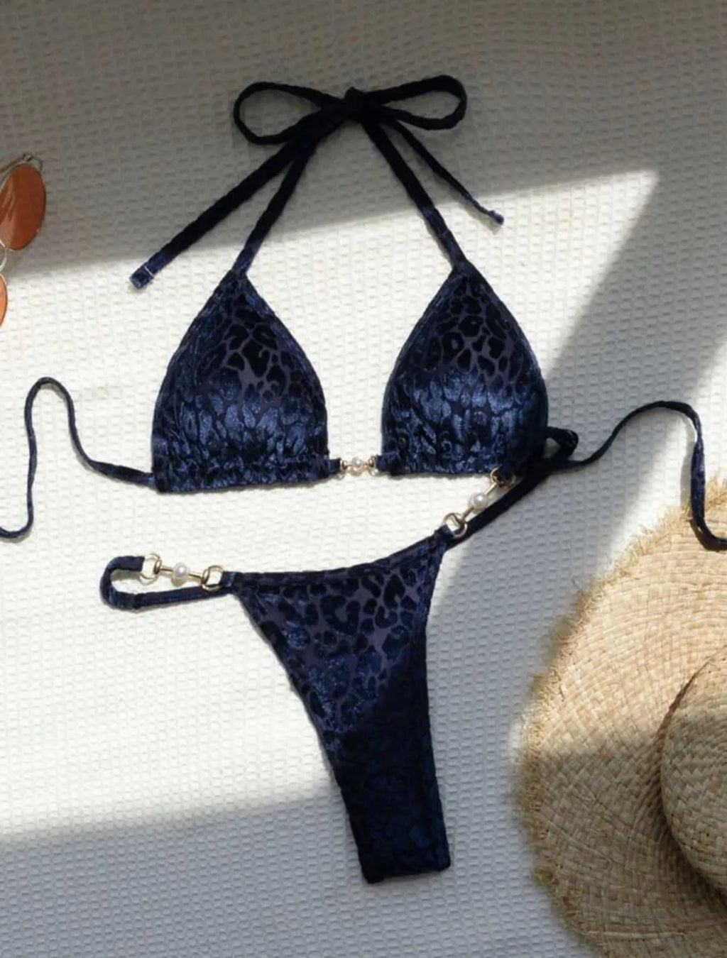 Women's blue leopard print bikini set on a yellow background, showing triangle top and briefs style.