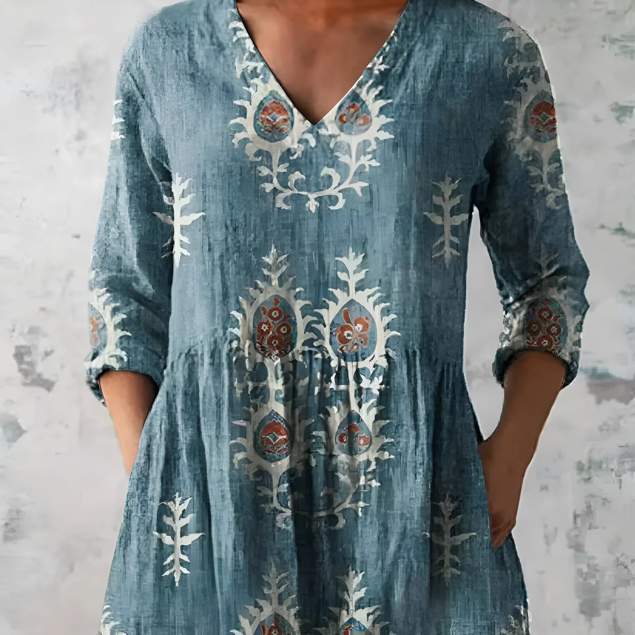 A woman wearing a vibrant printed loose-fitting dress with a wide waist and 3/4 length sleeves.