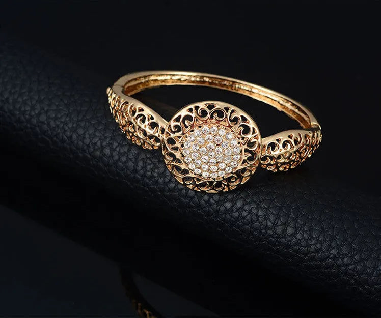 Gold jewellery four piece set with necklace, earrings, ring, and hand accessories featuring alloy and artificial gems