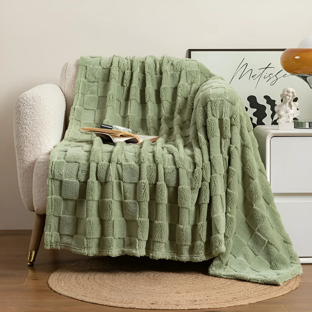 Thickened polyester blanket with geometric pattern in creamy white on a sofa