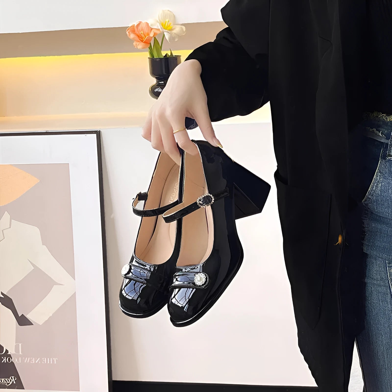 Women's black patent leather chunky heel shoes with round toe and buckle fastening on a white background.