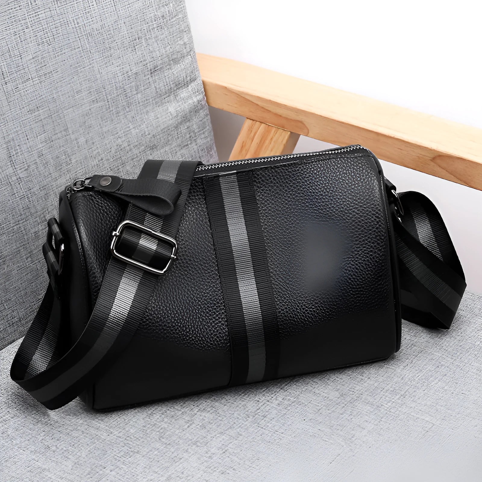 Black genuine leather crossbody bag showing front view with single shoulder strap