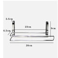 Silver stainless steel paper towel rack hanging on a wooden cabinet door.