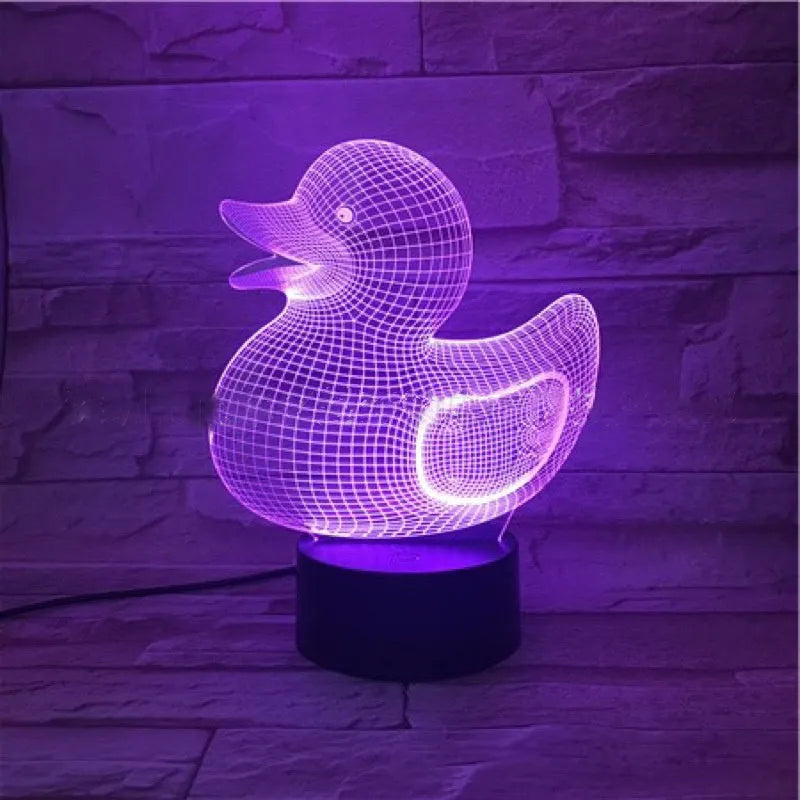 3D Little Yellow Duck night light glowing in multiple colours on a desk with remote control.