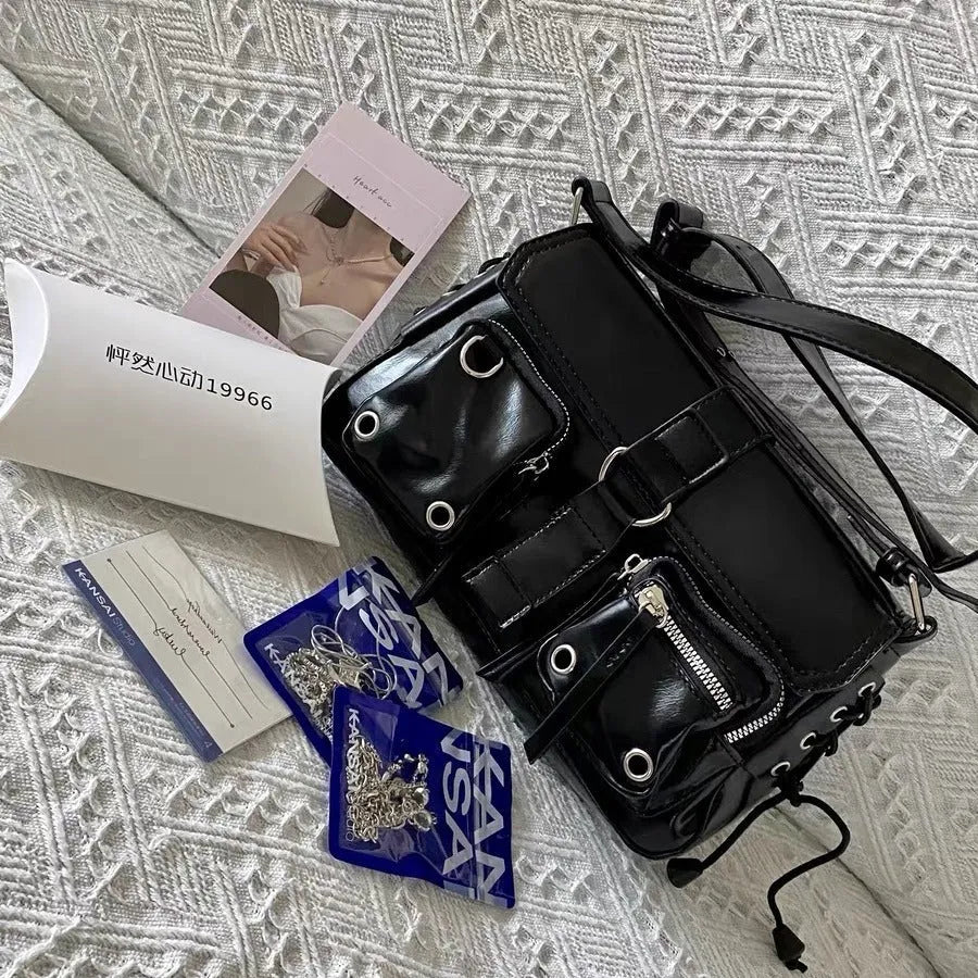 Black PU leather women's baguette messenger bag with adjustable strap and zippered internal compartment.