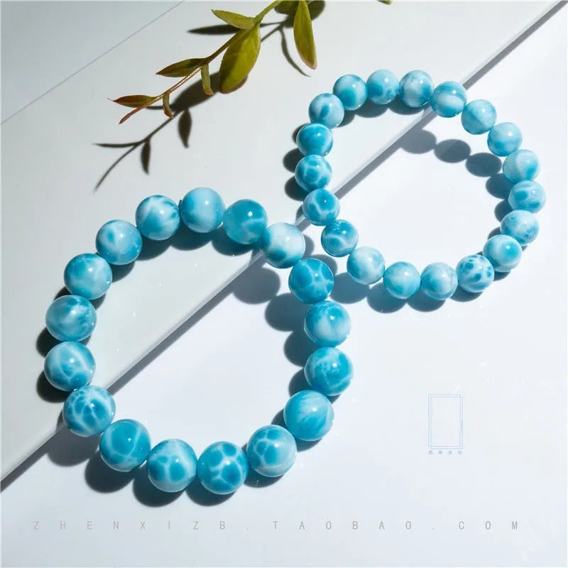 Blue Maillard-style Bodhi bracelet with a sea-pattern crystal stone and pearl accents on a wrist.