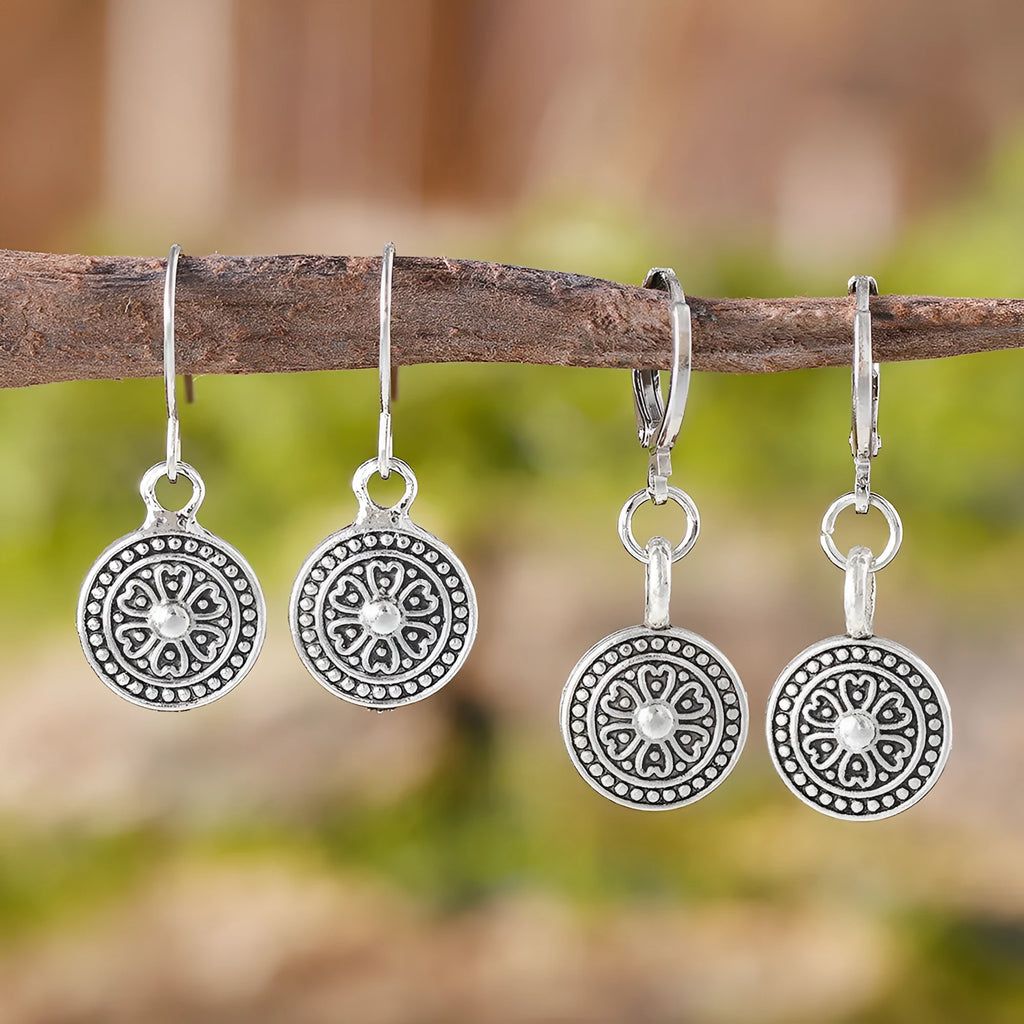 Close-up of a pair of women's geometric round bohemian retro style earrings with a distressed ethnic design in zinc alloy.
